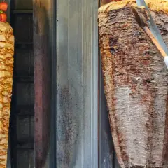 Dwa pionowe rożna z mięsem do kebaba, jeden z kurczakiem i pomidorkami, drugi z wołowiną. Zastanawiasz się, ile kebabów dziennie można sprzedać?