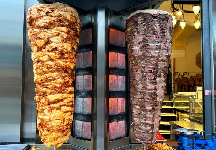 Dwa pionowe, obracające się rożny z mięsem na kebab: jeden z kurczaka, drugi z wołowiny.